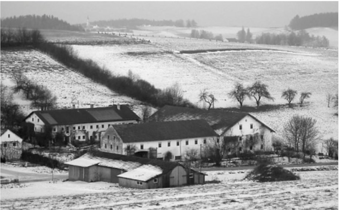 Hof in verschneiter Hügellandschaft